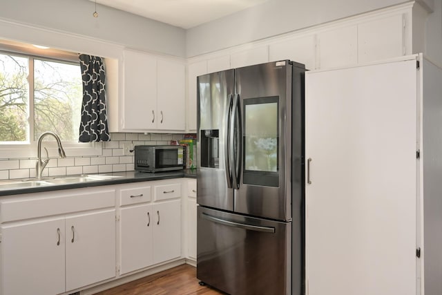 1158 Rockstone Ln, New Brighton, MN 55112 - kitchen with stainless steel appliances, a sink, white cabinets, dark countertops, and backsplash
