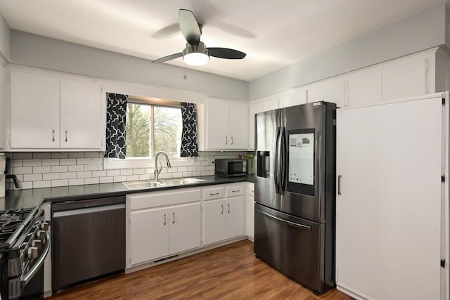 1158 Rockstone Ln, New Brighton, MN 55112 - kitchen with appliances with stainless steel finishes, a sink, dark countertops, backsplash, and ceiling fan