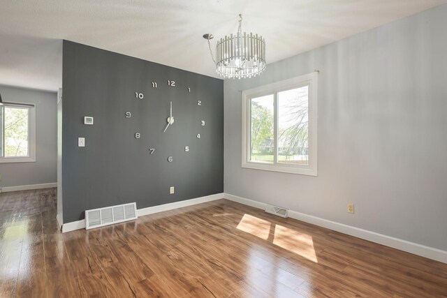 1158 Rockstone Ln, New Brighton, MN 55112 - spare room with healthy amount of natural light, a chandelier, wood finished floors, and baseboards
