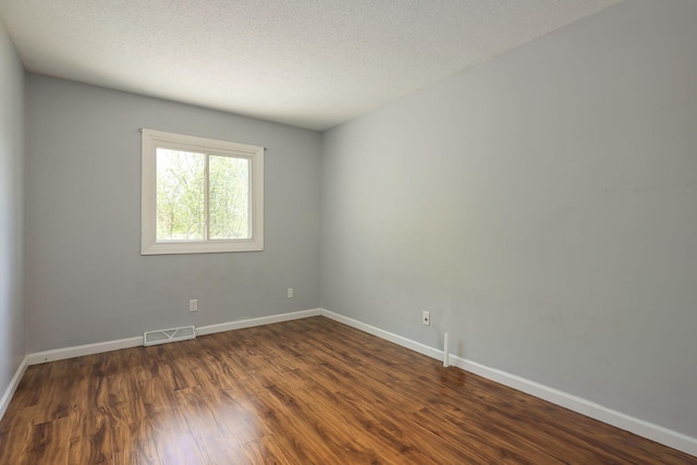 1158 Rockstone Ln, New Brighton, MN 55112 - unfurnished room featuring baseboards, dark wood-style flooring, and a textured ceiling