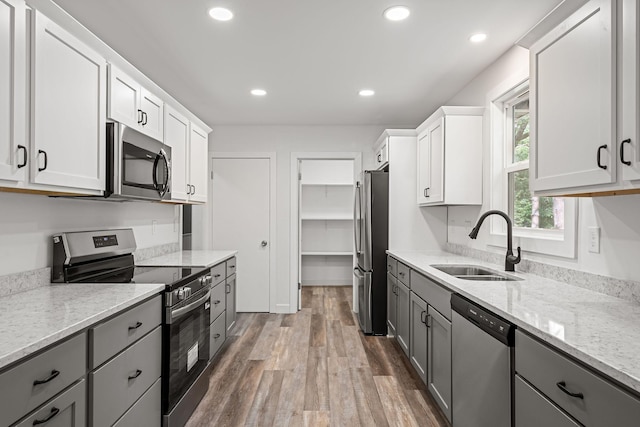 11600 Timberline Rd, Minnetonka, MN 55305 - kitchen with stainless steel appliances, gray cabinetry, a sink, wood finished floors, and recessed lighting