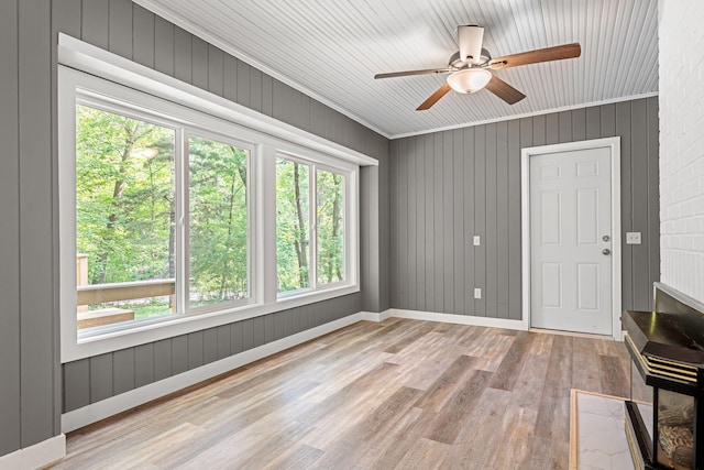 11600 Timberline Rd, Minnetonka, MN 55305 - empty room featuring wood finished floors, ceiling fan, ornamental molding, wood walls, and baseboards