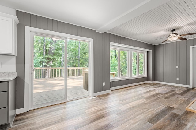 11600 Timberline Rd, Minnetonka, MN 55305 - unfurnished living room featuring a ceiling fan, light wood-style flooring, baseboards, and wood walls