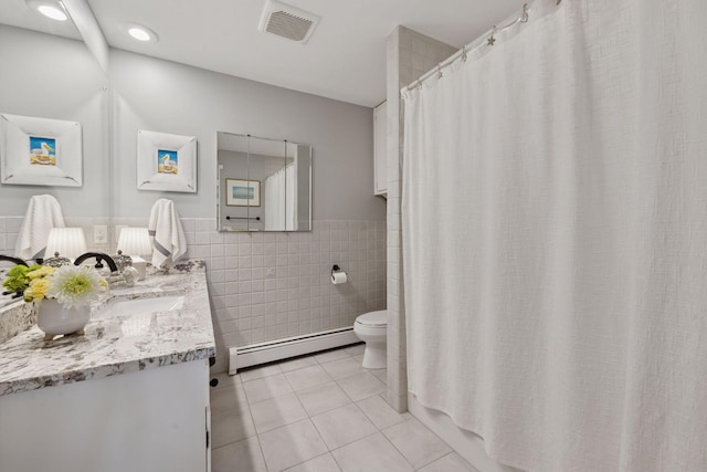 1811 Pulaski Rd, Buffalo, MN 55313 - full bathroom featuring a baseboard radiator, tile patterned floors, tile walls, vanity, and wainscoting