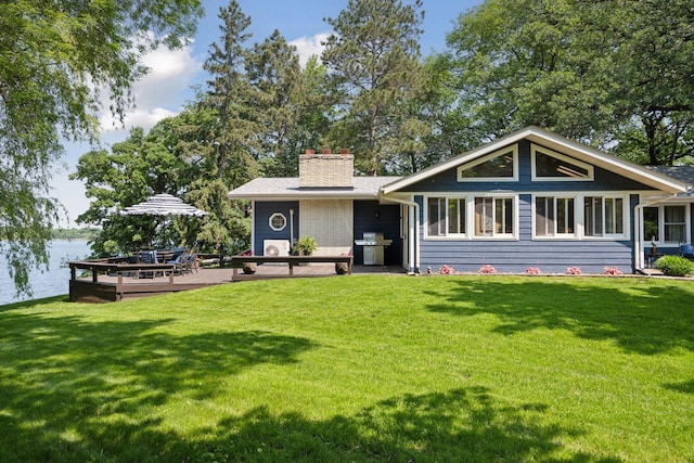 1811 Pulaski Rd, Buffalo, MN 55313 - back of property featuring a chimney, a yard, and a deck with water view