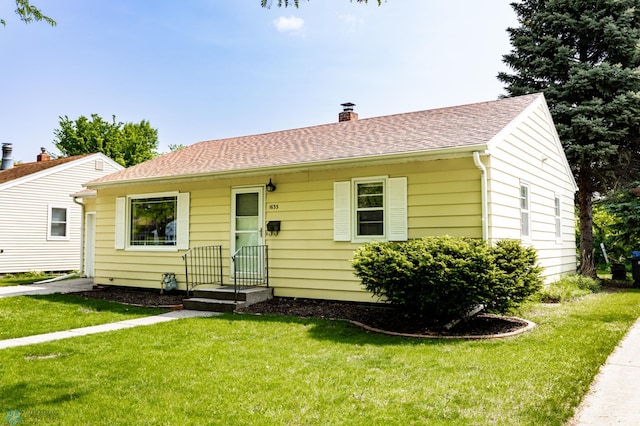 1633 1st St N, Fargo, ND 58102 - view of front of house featuring a front yard, a chimney, and a shingled roof