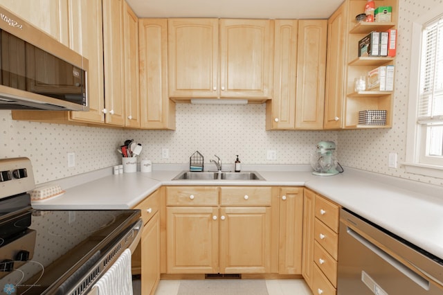 1633 1st St N, Fargo, ND 58102 - kitchen with appliances with stainless steel finishes, a sink, light brown cabinetry, open shelves, and wallpapered walls