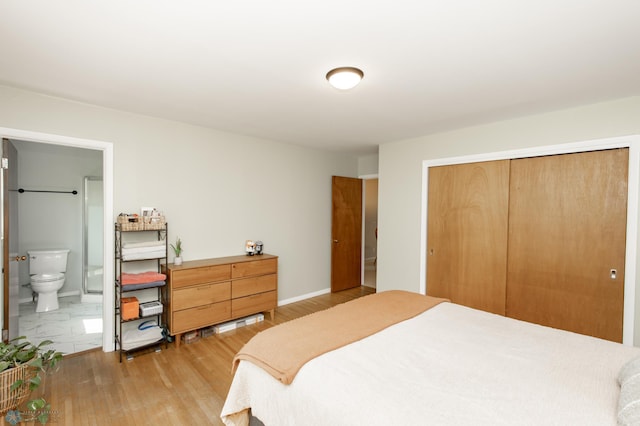 1633 1st St N, Fargo, ND 58102 - bedroom featuring a closet, light wood-style flooring, ensuite bath, and baseboards