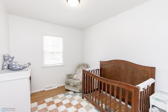1633 1st St N, Fargo, ND 58102 - bedroom featuring wood finished floors, baseboards, and a nursery area
