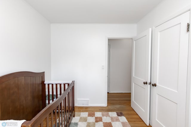 1633 1st St N, Fargo, ND 58102 - bedroom featuring wood finished floors, crown molding, a crib, and baseboards