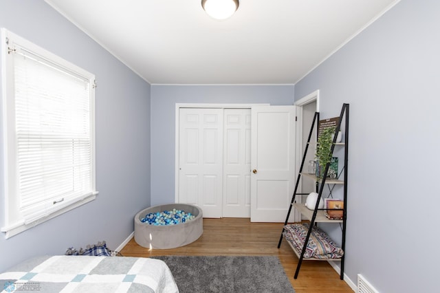 1633 1st St N, Fargo, ND 58102 - bedroom featuring wood finished floors, crown molding, and a closet