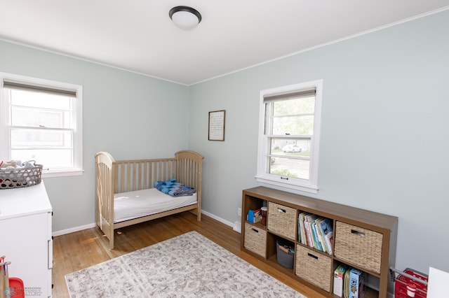 1633 1st St N, Fargo, ND 58102 - bedroom with wood finished floors, multiple windows, ornamental molding, and baseboards