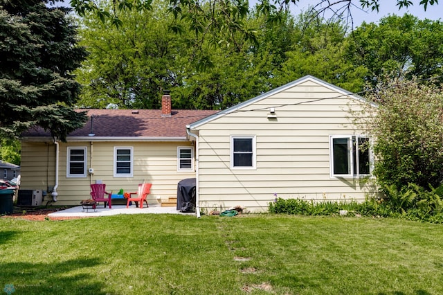 1633 1st St N, Fargo, ND 58102 - back of house with a patio area, a lawn, a chimney, and central air condition unit