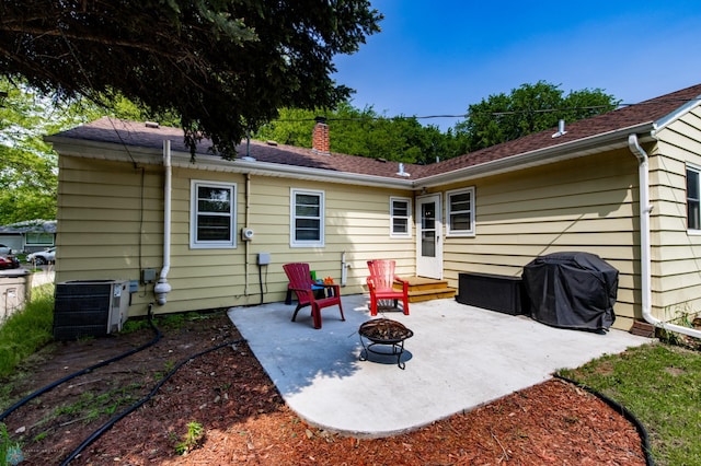 1633 1st St N, Fargo, ND 58102 - rear view of property with an outdoor fire pit, central AC, a patio, and a chimney