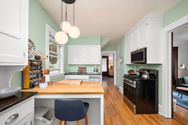 1144 Abell St, Saint Paul, MN 55117 - kitchen with stainless steel appliances, white cabinetry, light wood-type flooring, hanging light fixtures, and a sink