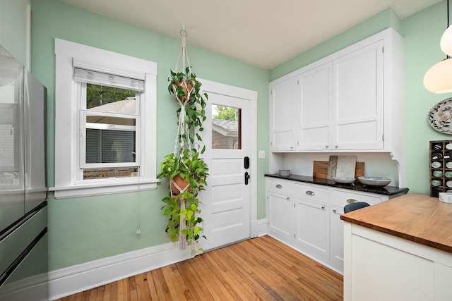 1144 Abell St, Saint Paul, MN 55117 - kitchen featuring white cabinetry, light wood finished floors, plenty of natural light, and freestanding refrigerator