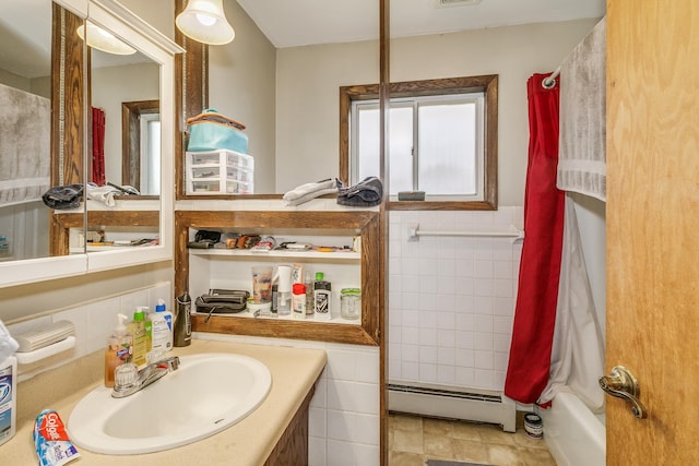 266 Janice St, Shoreview, MN 55126 - bathroom featuring baseboard heating, vanity, tile walls, and shower / tub combo