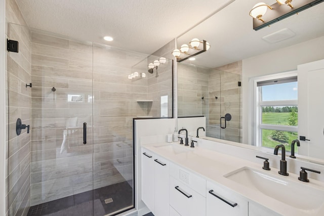 16149 Duvane Way, Lakeville, MN 55044 - full bath featuring double vanity, a shower stall, a textured ceiling, and recessed lighting