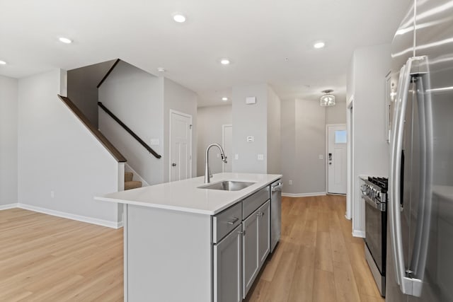6679 Bluestem Way, Minnetrista, MN 55331 - kitchen with a sink, appliances with stainless steel finishes, gray cabinetry, light wood-style floors, and light countertops