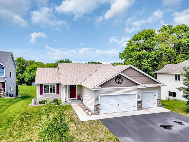 1217 Blossom Blvd NW, Isanti, MN 55040 - view of front facade featuring driveway, an attached garage, a front yard, and stone siding