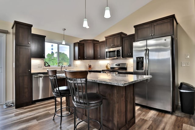 1217 Blossom Blvd NW, Isanti, MN 55040 - kitchen featuring stainless steel appliances, dark wood-style floors, dark brown cabinetry, decorative backsplash, and a kitchen island