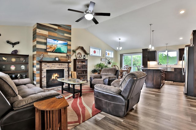 1217 Blossom Blvd NW, Isanti, MN 55040 - living area with ceiling fan, vaulted ceiling, dark wood-type flooring, a stone fireplace, and recessed lighting
