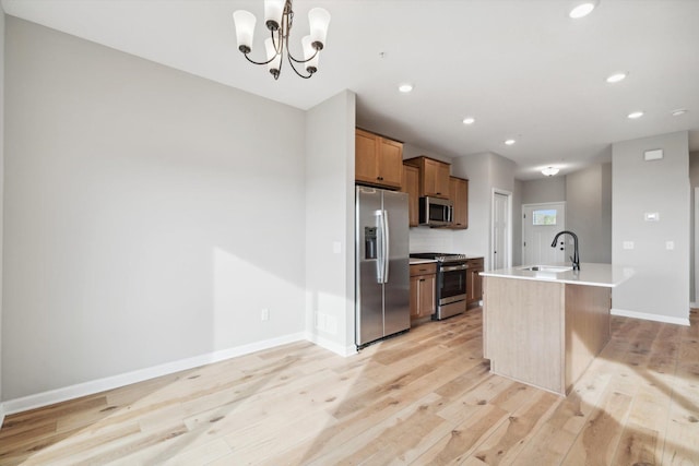 6683 Bluestem Way, Minnetrista, MN 55331 - kitchen with stainless steel appliances, light wood-type flooring, light countertops, baseboards, and a center island with sink