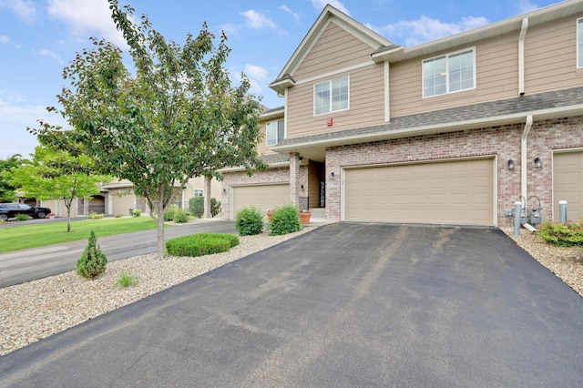 14246 Wilds Dr NW, Prior Lake, MN 55372 - townhome / multi-family property with brick siding, driveway, a garage, and a shingled roof