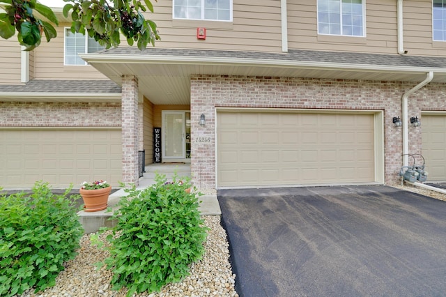14246 Wilds Dr NW, Prior Lake, MN 55372 - view of front of home with a garage, brick siding, driveway, and a shingled roof