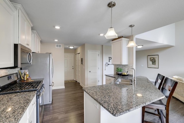 14246 Wilds Dr NW, Prior Lake, MN 55372 - kitchen with stainless steel appliances, backsplash, white cabinetry, dark wood-style floors, and a peninsula