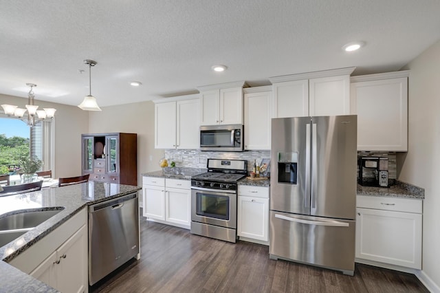 14246 Wilds Dr NW, Prior Lake, MN 55372 - kitchen with stainless steel appliances, tasteful backsplash, dark wood-type flooring, white cabinetry, and a chandelier