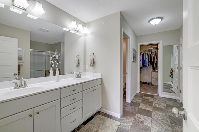 14246 Wilds Dr NW, Prior Lake, MN 55372 - bathroom featuring a spacious closet, double vanity, a shower stall, and stone finish flooring