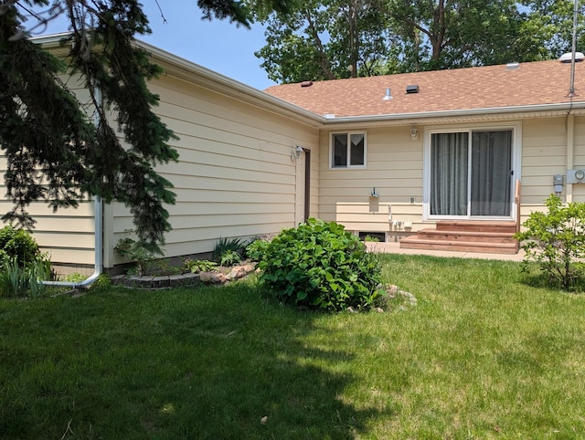 702 Hills Ln, Albert Lea, MN 56007 - rear view of property featuring entry steps, a lawn, and a shingled roof