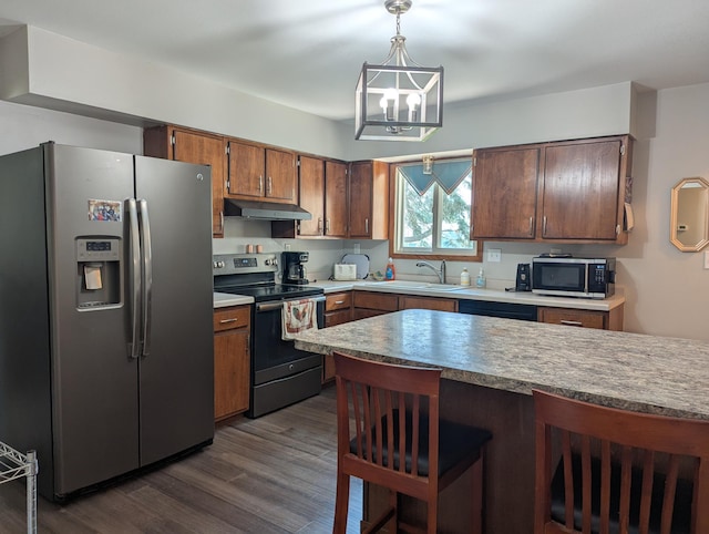 702 Hills Ln, Albert Lea, MN 56007 - kitchen with stainless steel appliances, under cabinet range hood, a sink, a chandelier, and decorative light fixtures