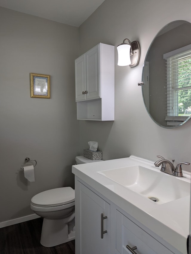 702 Hills Ln, Albert Lea, MN 56007 - bathroom with toilet, vanity, wood finished floors, and baseboards