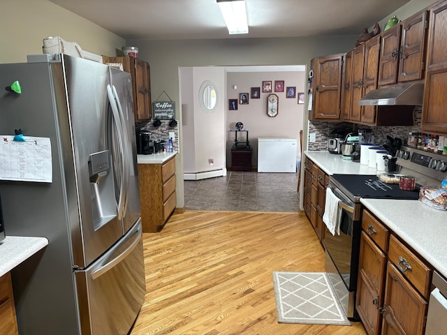 505 Lindquist St W, Onamia, MN 56359 - kitchen featuring stainless steel refrigerator with ice dispenser, electric range, under cabinet range hood, a baseboard heating unit, and light countertops