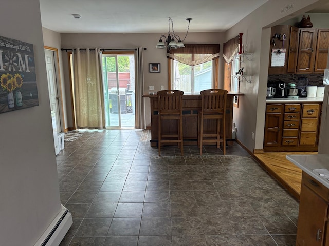 505 Lindquist St W, Onamia, MN 56359 - dining area with baseboard heating and dark stone finish floors