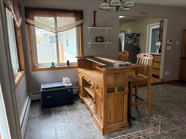 505 Lindquist St W, Onamia, MN 56359 - dining area with a chandelier, a baseboard heating unit, baseboards, and stone finish floors
