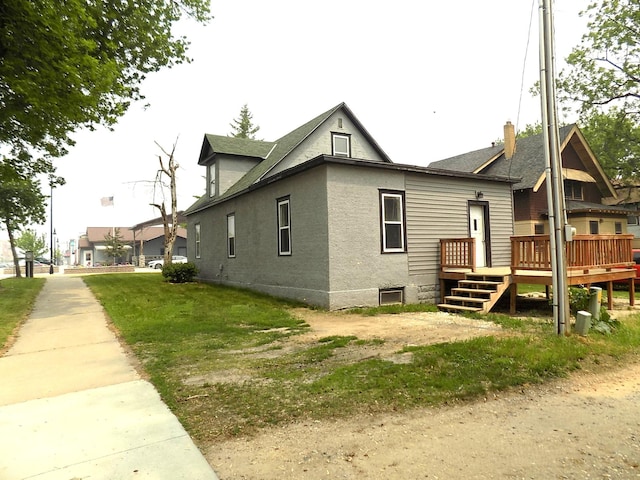 101 1st St SE, Baudette, MN 56623 - view of side of property with a deck and stucco siding