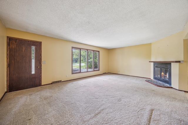4399 124th Ave, Clear Lake, MN 55319 - unfurnished living room featuring a glass covered fireplace, carpet, baseboards, and a textured ceiling