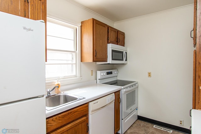 1614 2nd St N, Fargo, ND 58102 - kitchen featuring white appliances, a sink, brown cabinetry, light countertops, and baseboards