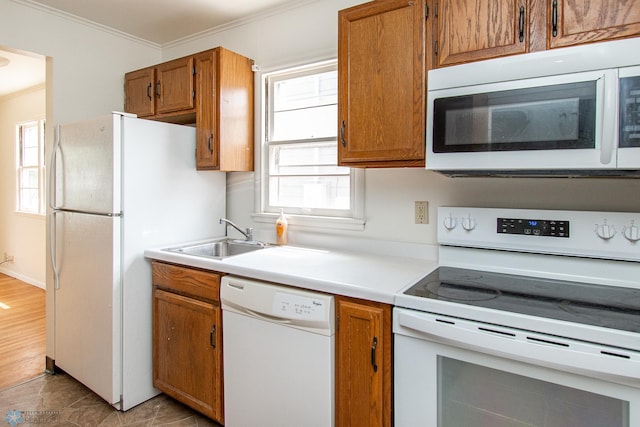 1614 2nd St N, Fargo, ND 58102 - kitchen featuring white appliances, ornamental molding, a sink, brown cabinetry, and light countertops