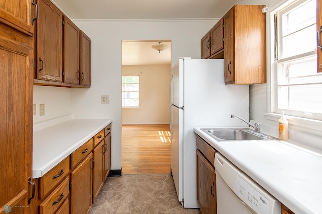 1614 2nd St N, Fargo, ND 58102 - kitchen featuring dishwasher, brown cabinets, light countertops, a sink, and crown molding