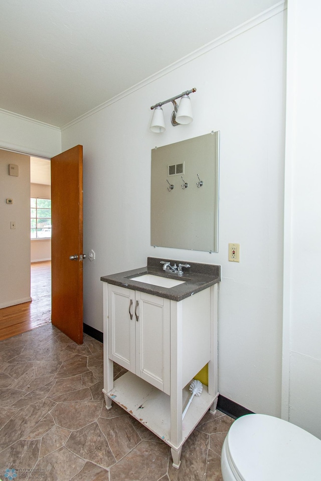 1614 2nd St N, Fargo, ND 58102 - half bath with vanity, crown molding, toilet, and baseboards
