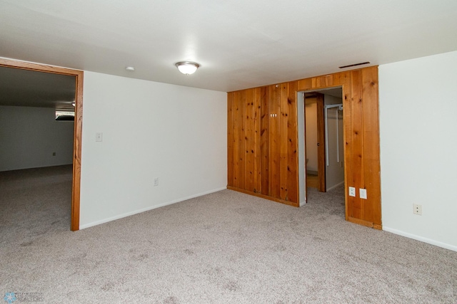 1614 2nd St N, Fargo, ND 58102 - spare room featuring carpet floors, wood walls, and baseboards