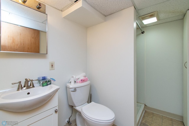 1614 2nd St N, Fargo, ND 58102 - bathroom with a stall shower, toilet, vanity, a paneled ceiling, and baseboards