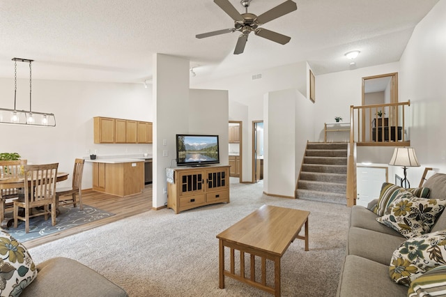 13408 Ximines Ln N, Champlin, MN 55316 - living area with vaulted ceiling, stairway, light carpet, a ceiling fan, and a textured ceiling