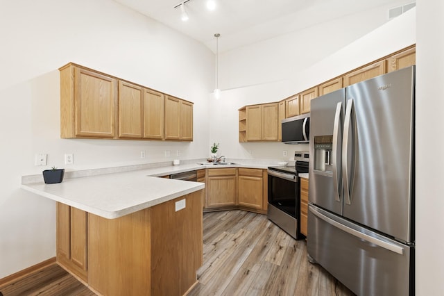 13408 Ximines Ln N, Champlin, MN 55316 - kitchen featuring appliances with stainless steel finishes, a peninsula, open shelves, light wood finished floors, and track lighting