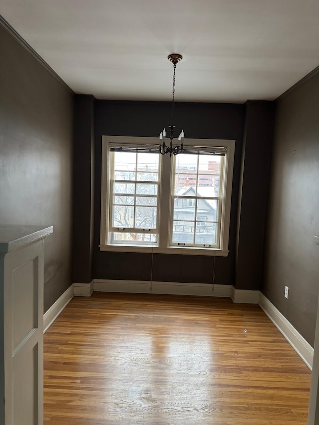 2615 Park Ave Unit 310, Minneapolis, MN 55407 - unfurnished dining area featuring light wood-style floors, a chandelier, and baseboards