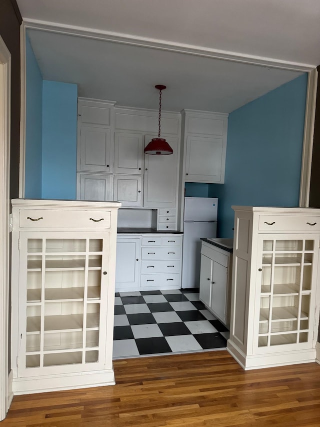 2615 Park Ave Unit 310, Minneapolis, MN 55407 - kitchen with freestanding refrigerator, tile patterned floors, pendant lighting, white cabinetry, and dark countertops